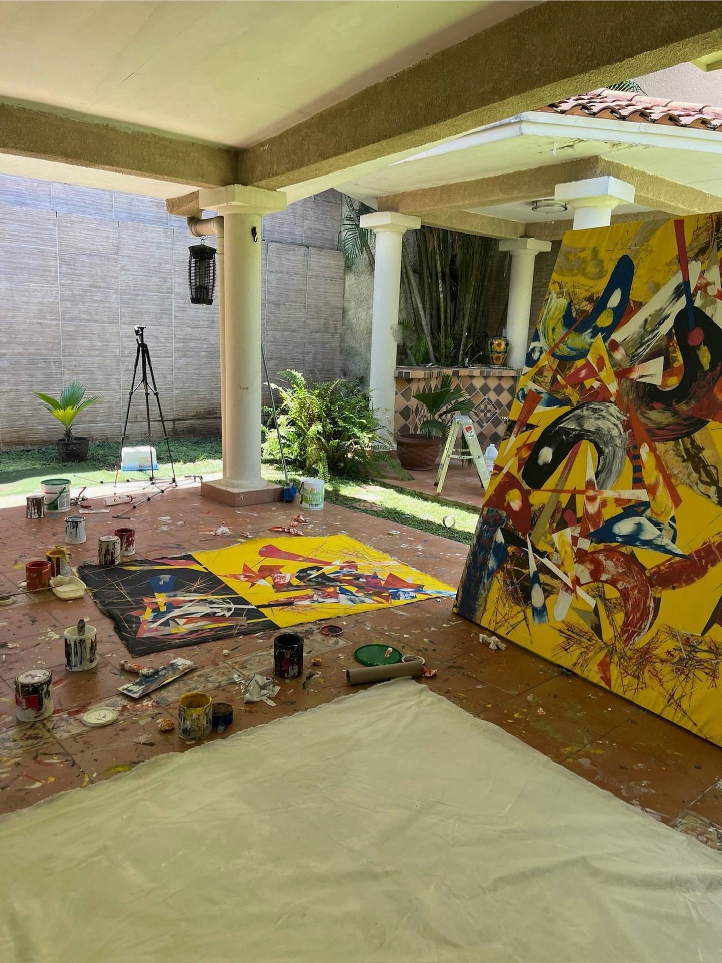 Artwork in progress outdoors, with paint tubes and a palette.