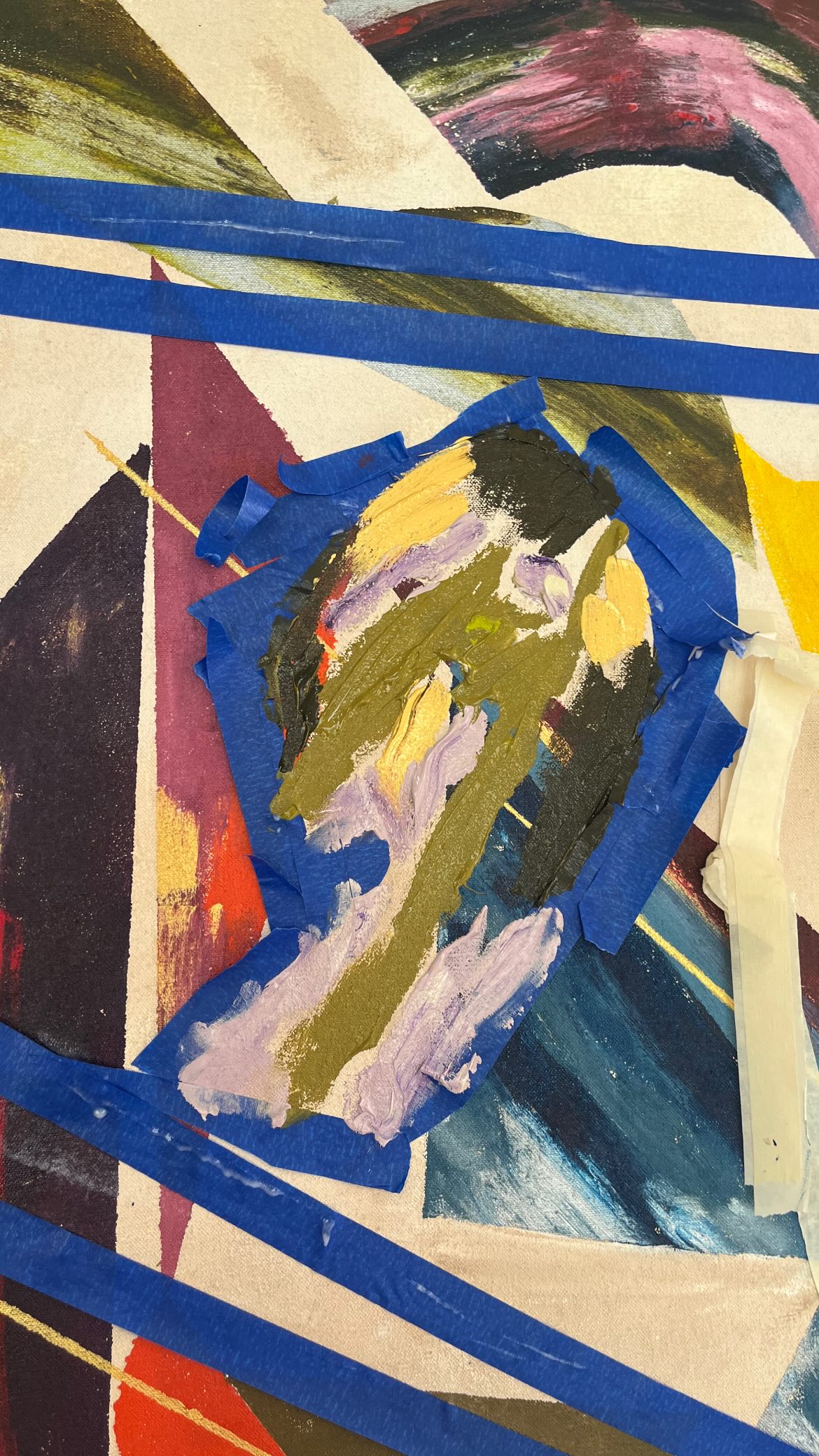 Artwork being created outdoors on the grass, surrounded by paint tubes.